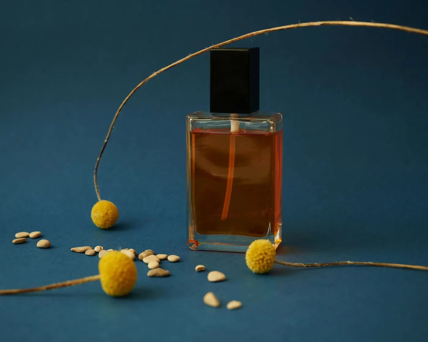 Editorial still life of amber fragrance bottles on dark surface